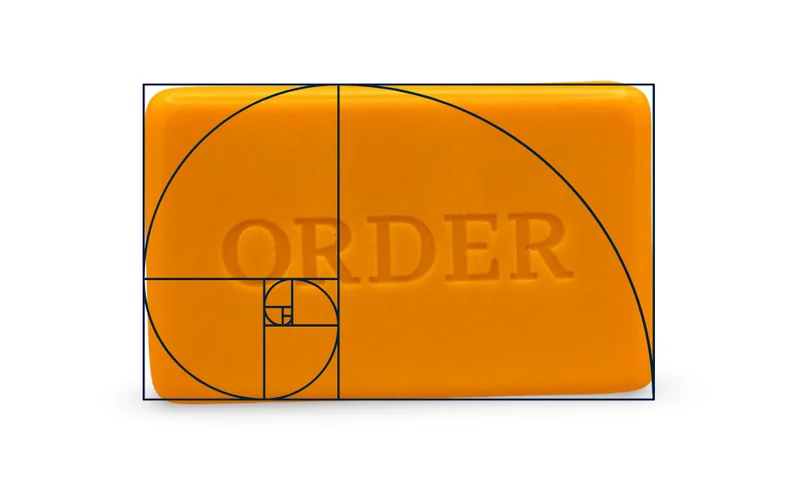 An Order Soap bar poured in a golden ratio mold, with the golden spiral drawn over it
